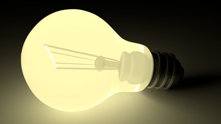 Glowing light bulb standing out against a dark background