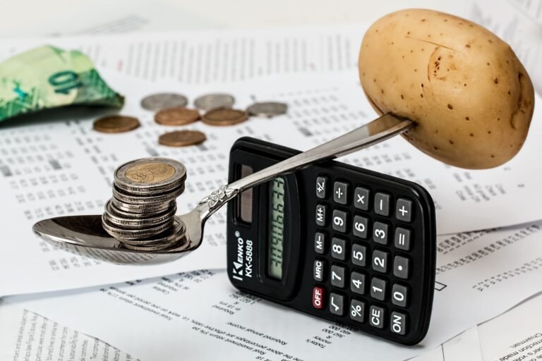 Coins and calculator illustrating how to budget on a low income without feeling miserable